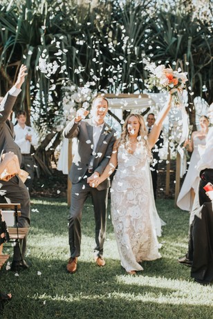 Newlyweds celebrate with confetti at their outdoor wedding ceremony