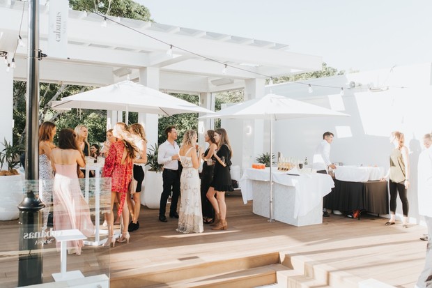 Outdoor social gathering with people in elegant attire and drinks