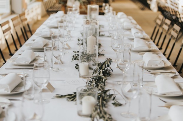 Elegant wedding table setting with candles and greenery decorations