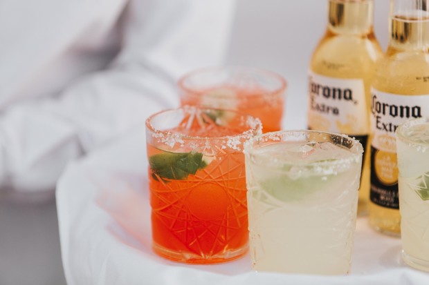 Refreshing cocktails and Corona beers on a white table