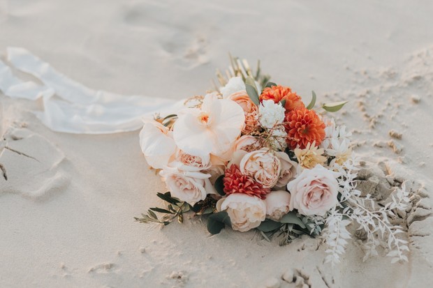 A beautiful flower bouquet resting on the sandy beach