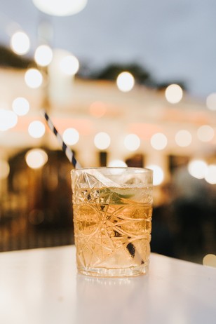 Cocktail with straw on a table with bokeh lights in the background