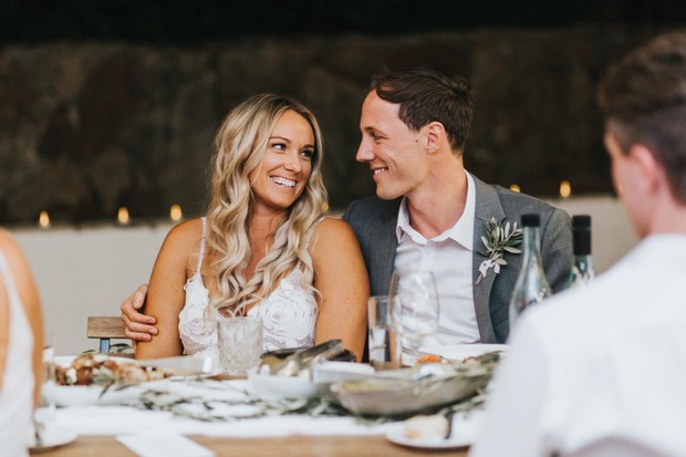 Happy bride and groom smiling at each other during wedding reception