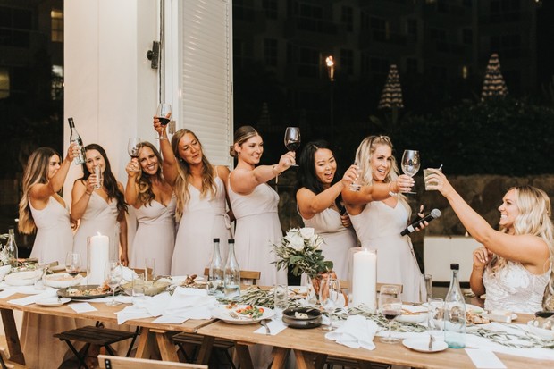 Bridesmaids raising glasses for a toast during wedding celebration