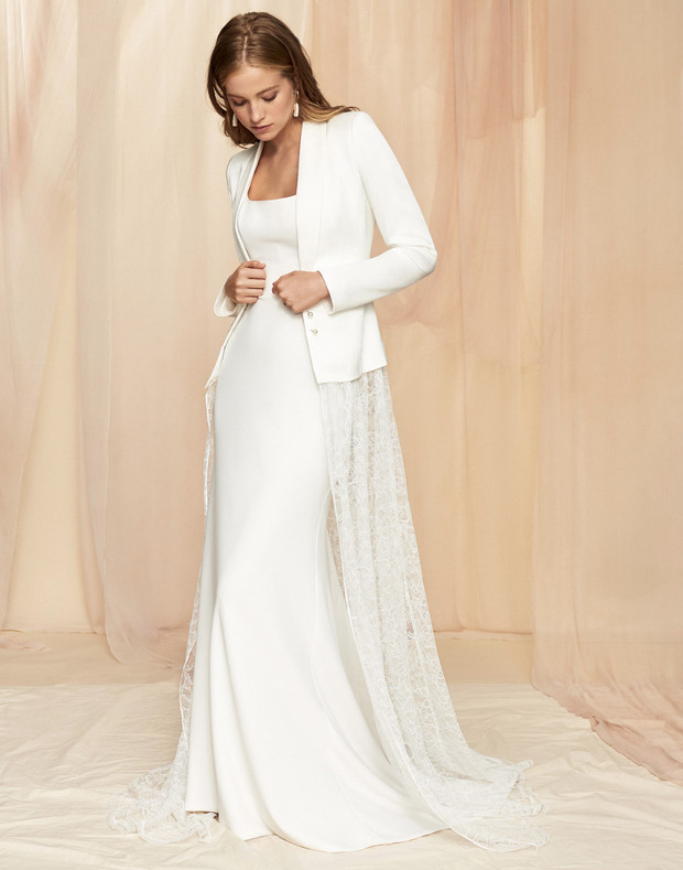 Bride in white wedding dress with jacket and lace train