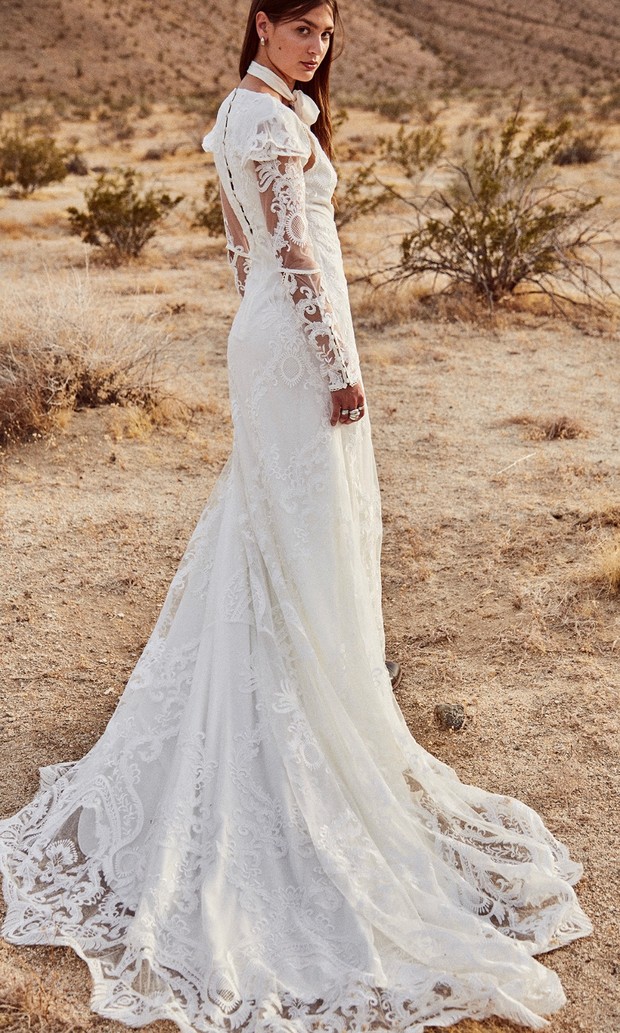 Woman in lace wedding dress in desert landscape