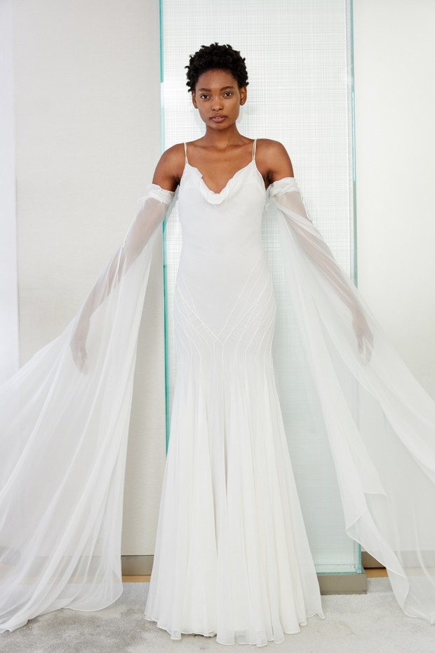 Elegant bride in flowing white wedding dress with sleeves