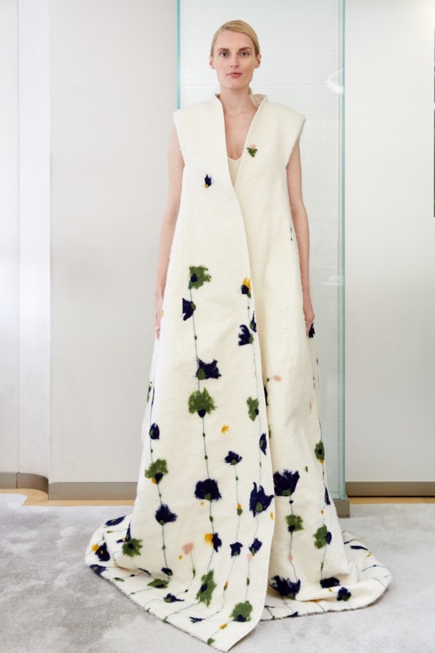 Woman in floral printed white dress, standing in front of mirror