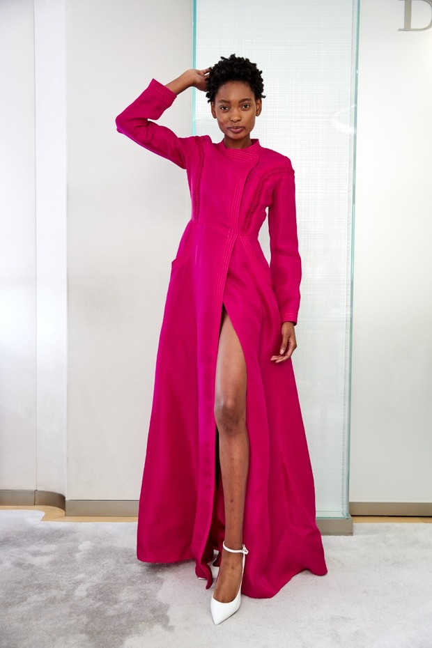 Woman in a magenta dress posing with a leg up, fashion statement