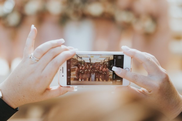 Taking a photo of the wedding party with a smartphone