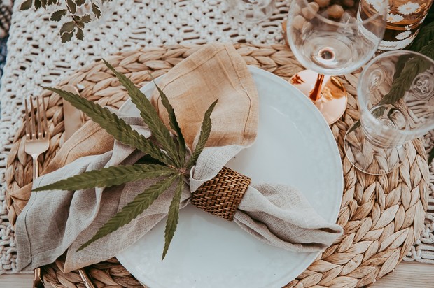 A rustic table setting with a cannabis leaf accent on the napkin