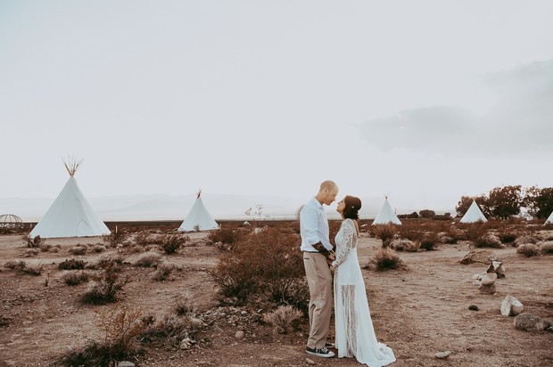 Couple at teepee wedding looking at each other in a desert setting