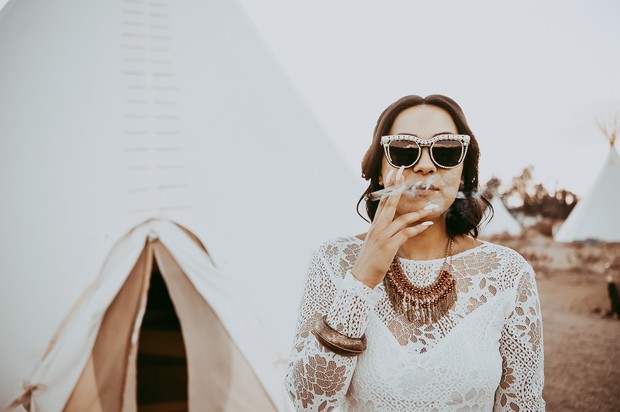 Woman in white lace dress smoking, wearing sunglasses