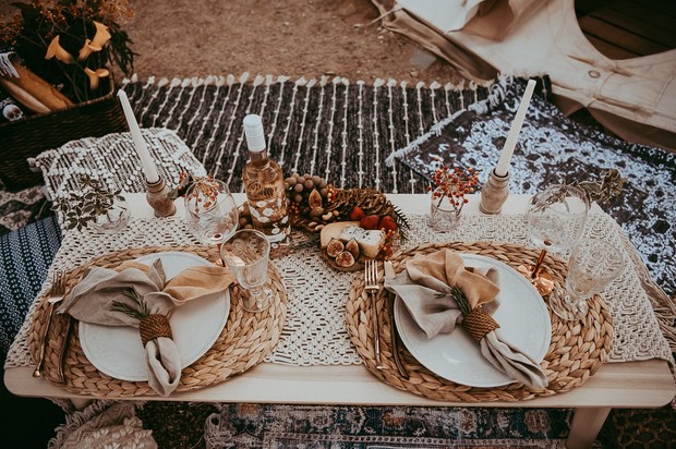 Romantic picnic setting with food and wine on a table outdoors