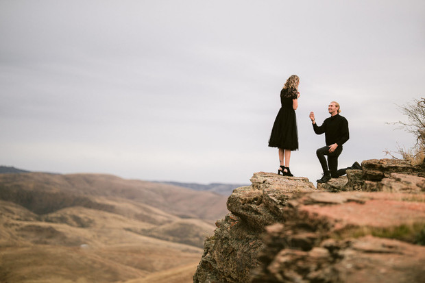 Romantic proposal on a cliff edge with stunning mountain view scenery