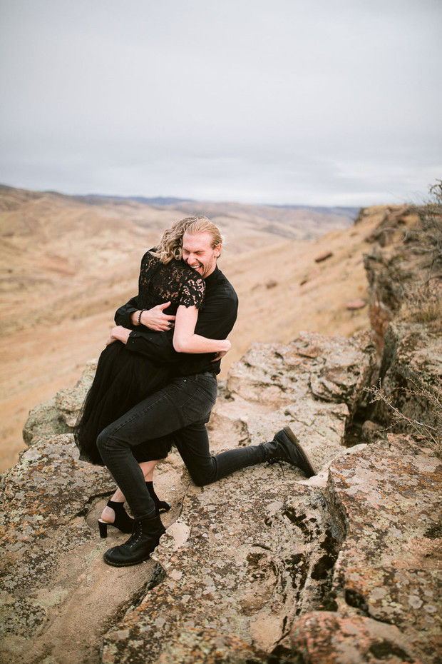 Happy man hugs woman after a proposal in the mountains