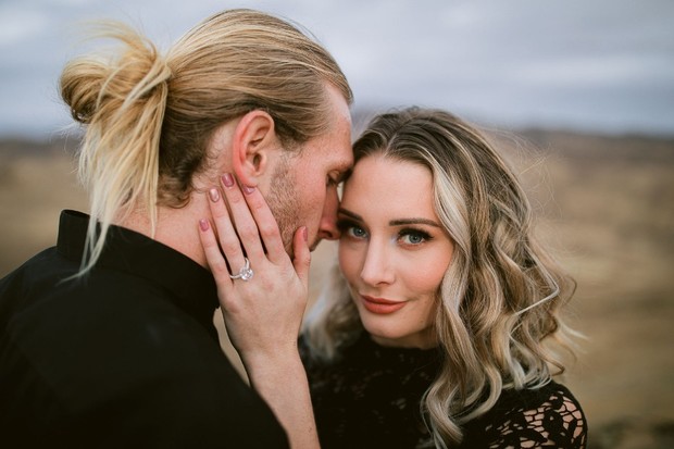 A loving couple embraces with a beautiful engagement ring in a moment of intimacy