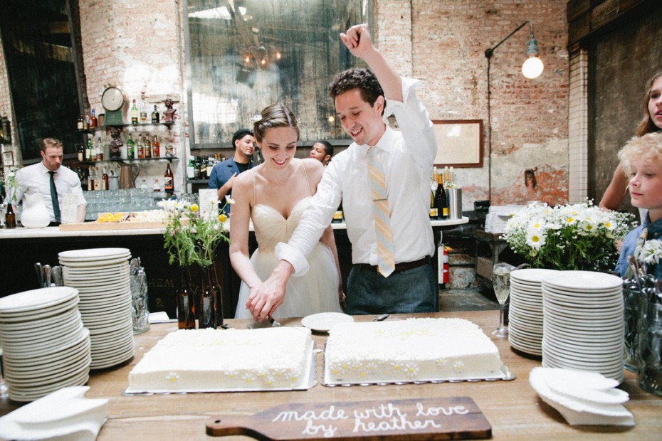 Bride and groom cutting the cake at beer hall wedding