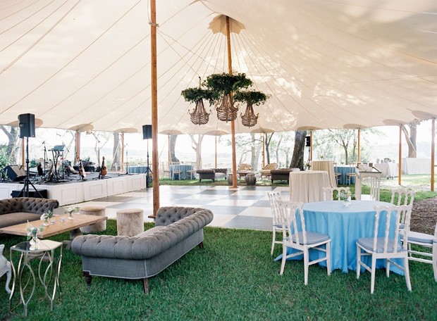 Elegant outdoor event tent with furniture and stage setup