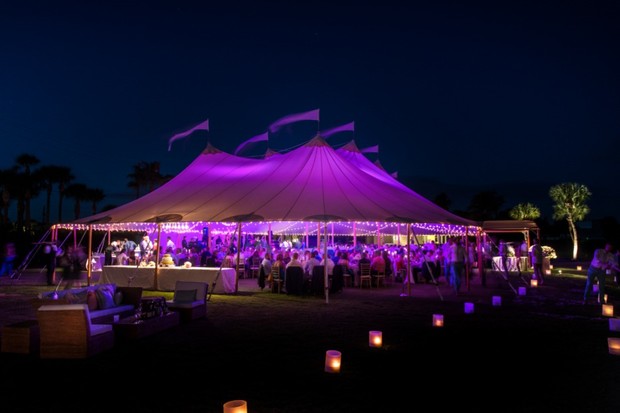 Festive nighttime outdoor event with purple tent lighting