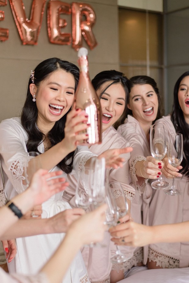 Bridesmaids popping champagne and toasting for the bachelorette party