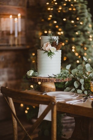 wintertime wedding cake topped with flowers and pinecones