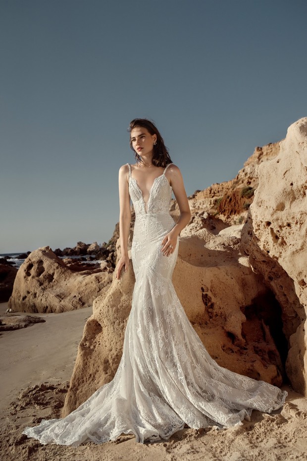 Elegant bride in a mermaid gown on a sunny beach background