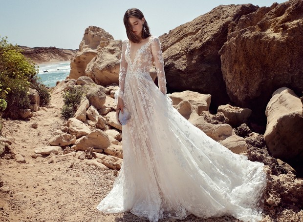 Elegant bride in a lace wedding dress, on a rocky beach landscape