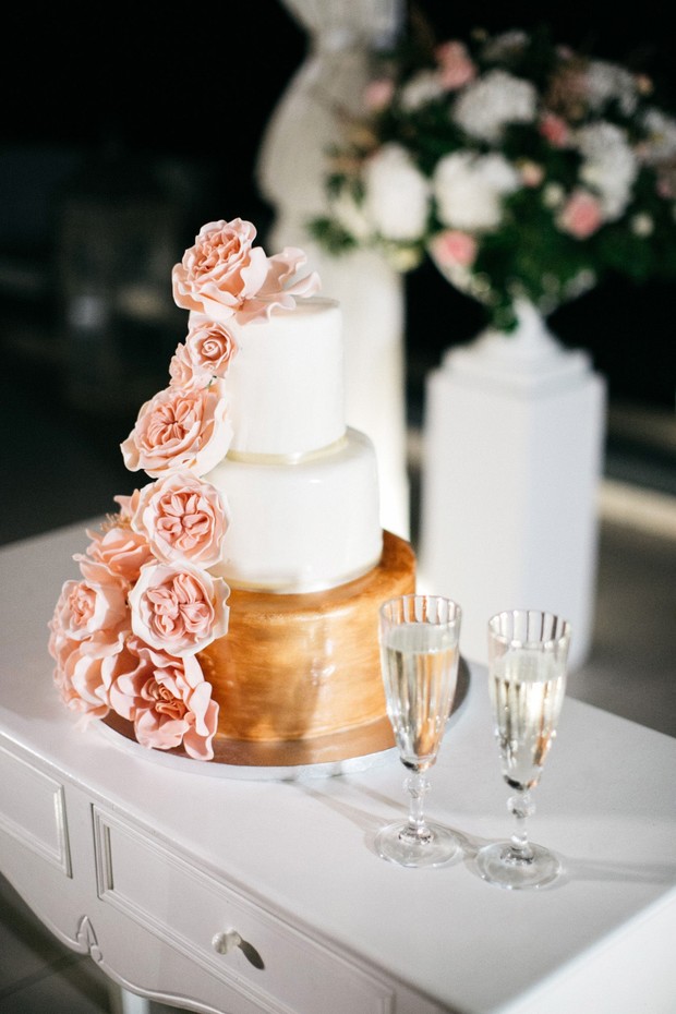 gold and white wedding cake with blush roses