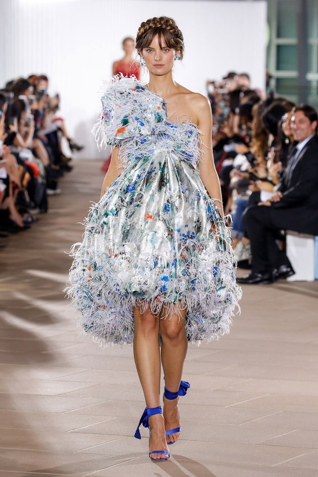 Fashion model in a floral print and feathered one-shoulder dress