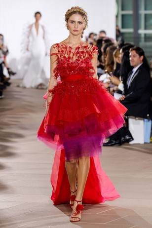 Fashion model in a stunning red feathered and layered gown