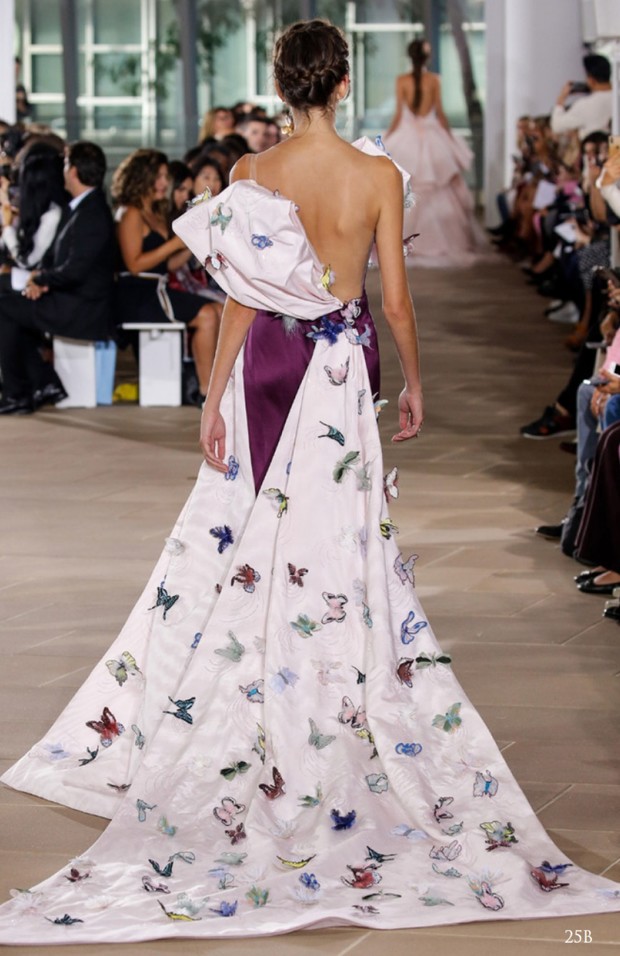 Fashion model wearing a butterfly embellished gown on a runway