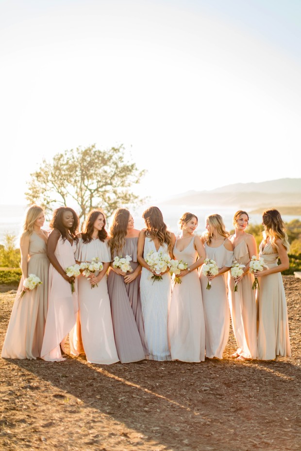 bridesmaids in muted pink and champagne dresses at sunset