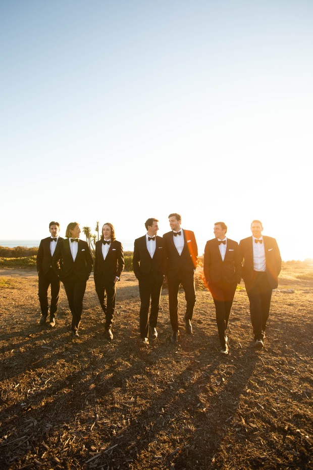 groom and his men in tuxedos at sunset
