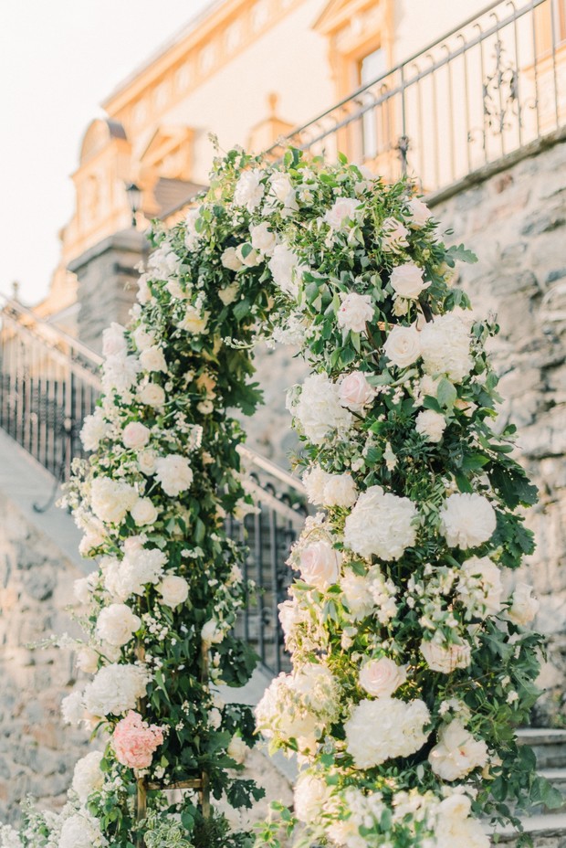 Elegant floral archway at an outdoor wedding venue