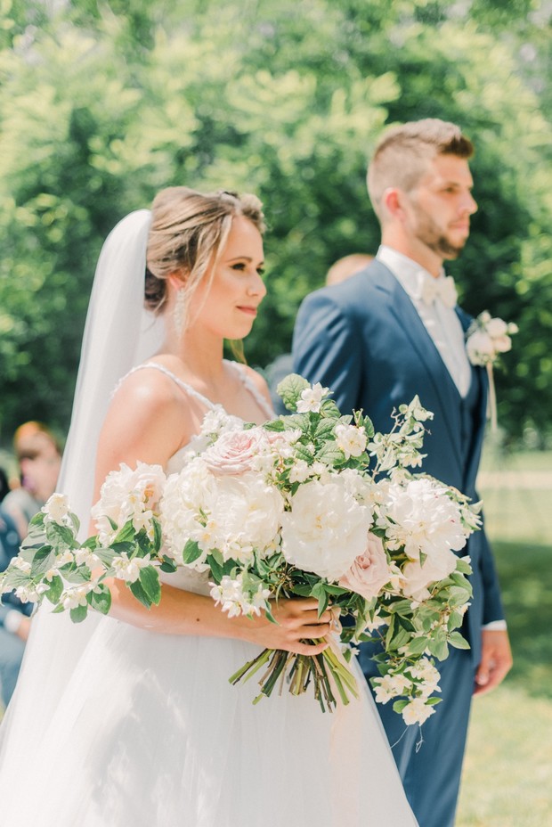 Bride and groom at a wedding ceremony, holding bouquet of flowers
