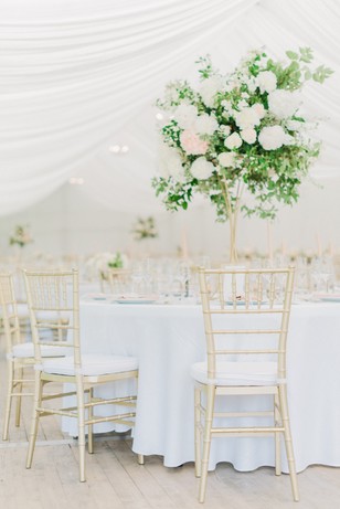 Elegant wedding reception tables decorated with flowers and chairs