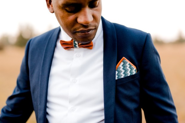 groom with beaded leather pocket square and bow tie