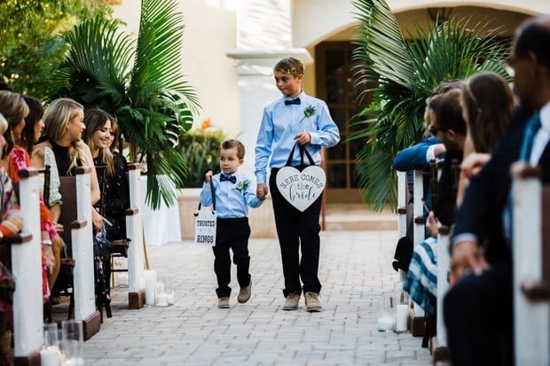 ring bearers with here comes the bride signs
