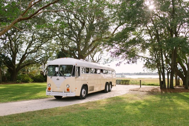 Vintage tour bus on a tree lined road by the water