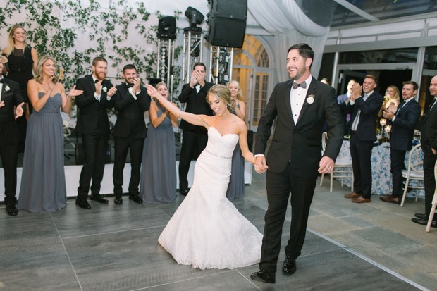 Bride and groom enter their wedding reception smiling