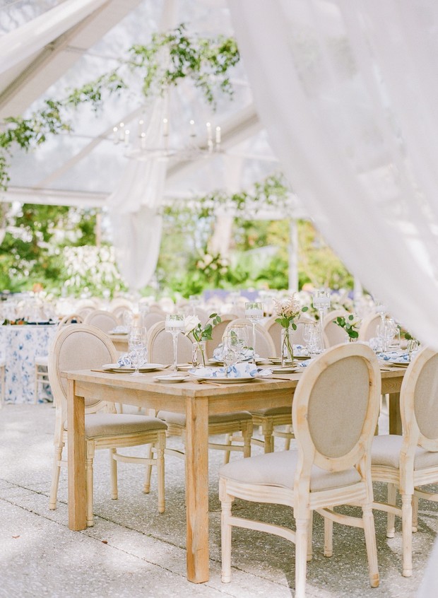 Elegant wedding reception tables under a sheer tent