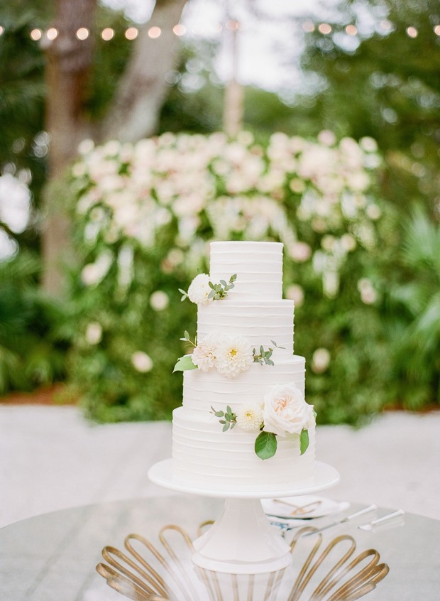 Elegant white four tier wedding cake with floral accents