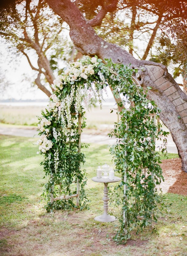 Outdoor wedding arch with white flowers and greenery