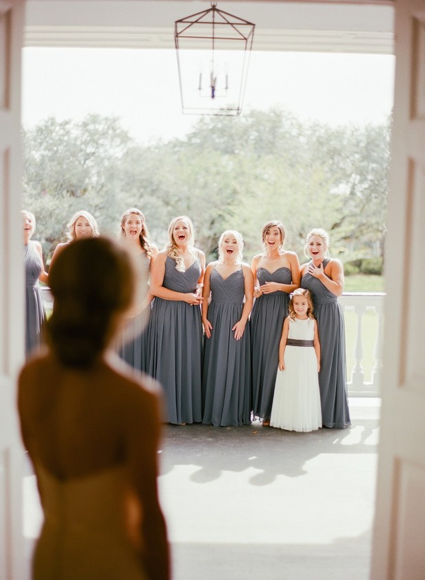 Bride reveal elicits surprise from bridesmaids and flower girl
