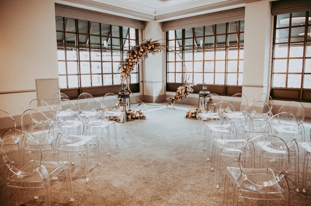 wedding ceremony with ghost chairs and giant wreath floral backdrop
