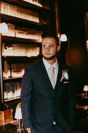 groom in navy blue suite and ivory tie