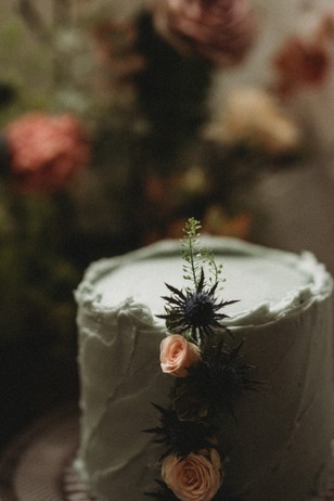 wedding cake with rose buds and thistles