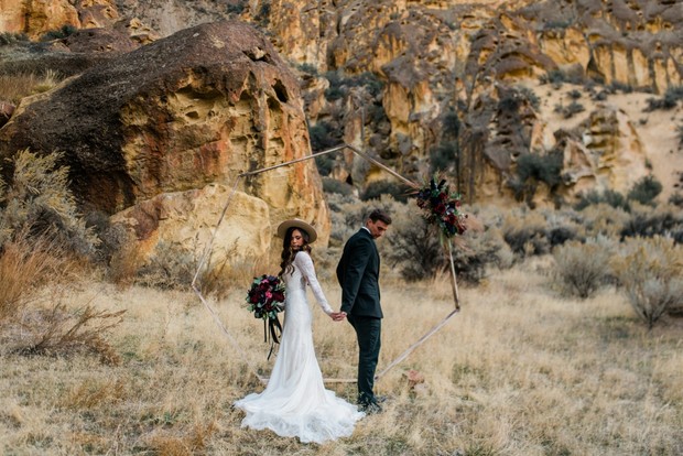 Bride and groom hold hands in desert wedding setting