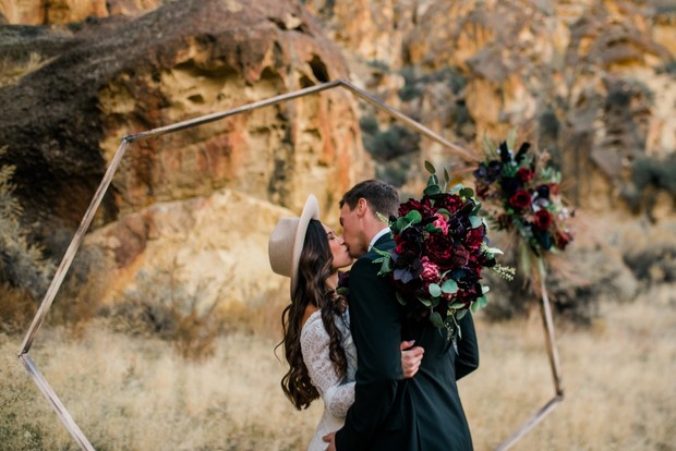 Bride and groom kissing at desert wedding ceremony